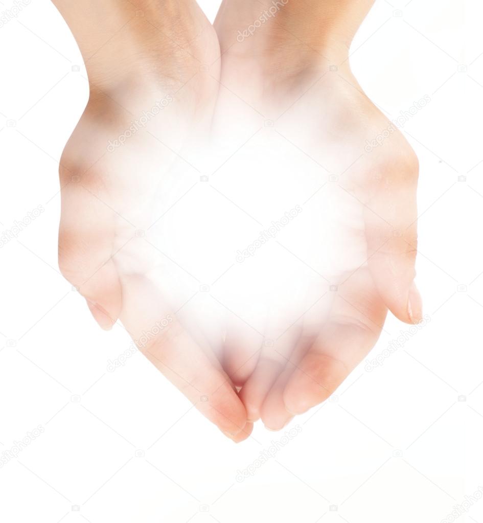Female hands holding a brilliant shine in the dark