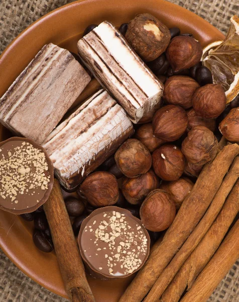 Sweets, cinnamon, nuts and coffee beans on a saucer — Stockfoto