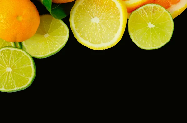 Sliced citrus fruits isolated on black — Stock Photo, Image