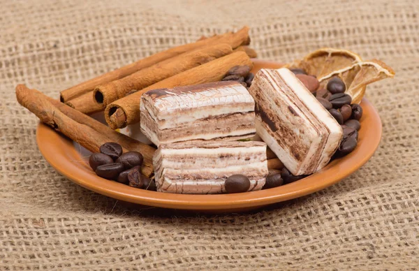 Sweets, cinnamon, coffee beans on a saucer — Stock Photo, Image