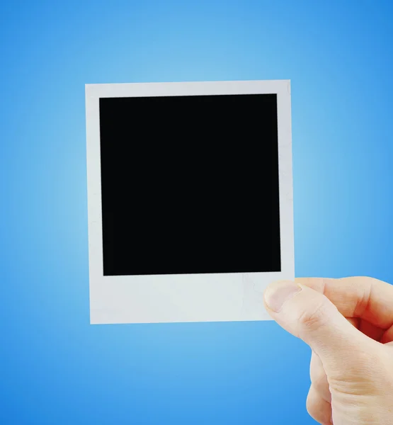 Photo in hand isolated on blue — Stock Photo, Image