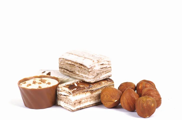 Chocolate and nuts over white — Stock Photo, Image