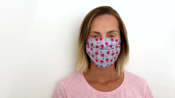 여자들은 코로나 바이러스로 보호 된 마스크를 쓴다. 카메라를 열심히 보고 있는 마스크를 쓴 여자 19. — 비디오