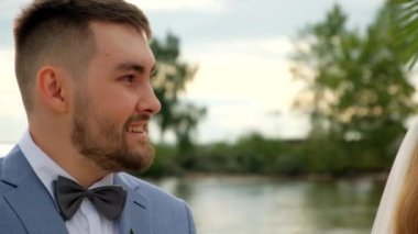 Mutlu gülümseme damat deniz kıyısında düğün töreni. Papyon yakışıklı insanlara yakışıyor..