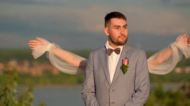 Mutlu evlilik çifti gelin ve damat gülümseyerek birbirlerine sarılıyorlar..