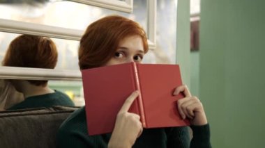 Güzel kız kitap okuyor. Kızıl saçı kapat. Sayfa 4K 'de kadın eğlencesi