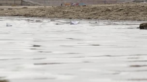 Орігамі паперовий човен, що плаває водою в спокійному озері. Креативна подорож на кораблях . — стокове відео