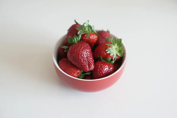 Fresas en taza roja sobre la mesa — Foto de Stock