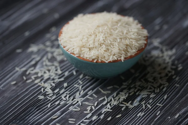 Vitt ris i turkos kopp på en trä bakgrund — Stockfoto