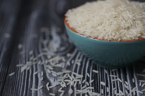 Weißer Reis in türkisfarbener Tasse auf Holzgrund — Stockfoto