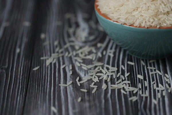 Белый рис в бирюзовой чашке на деревянном фоне — стоковое фото