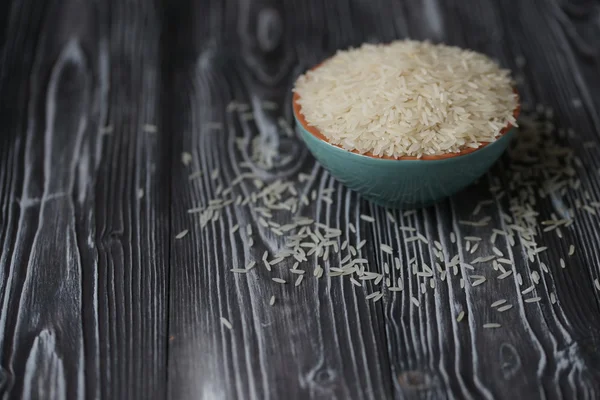 Arroz blanco en taza de turquesa sobre fondo de madera — Foto de Stock