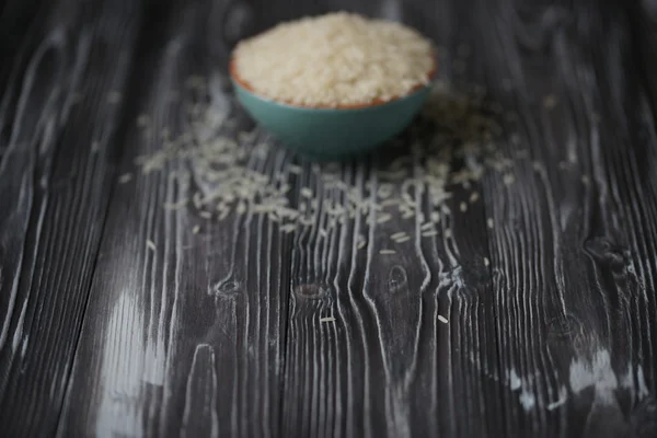 Weißer Reis in türkisfarbener Tasse auf Holzgrund — Stockfoto