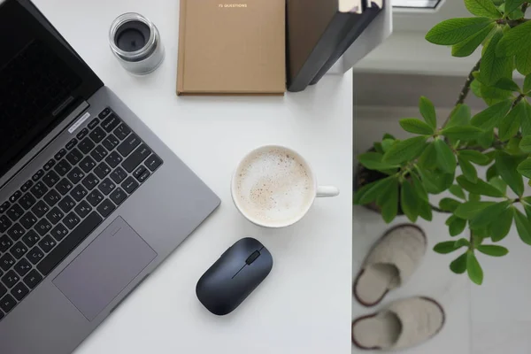 自宅にノートパソコンとコーヒーカップ付きのオフィスデスク — ストック写真