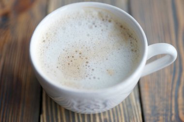 Süt köpüklü beyaz kahve kupası.