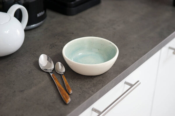 Empty bowl and two spoons on the table in the kitchen