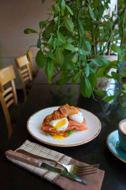 Kruvasan ve haşlanmış yumurtayla kahvaltı.