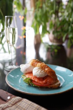 Somon balıklı kruvasan ve bir restorandaki masada haşlanmış yumurta.