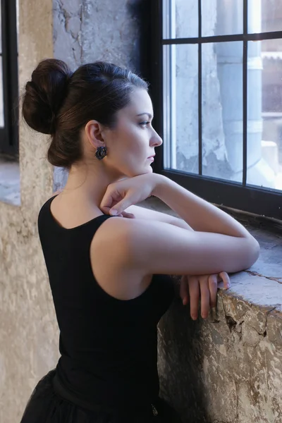 Giovane donna in piedi alla finestra — Foto Stock