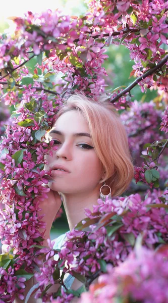Junge Frau in rosa Blumen — Stockfoto