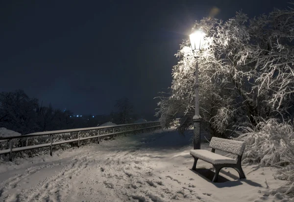 Bemch e lâmpada à noite com neve — Fotografia de Stock