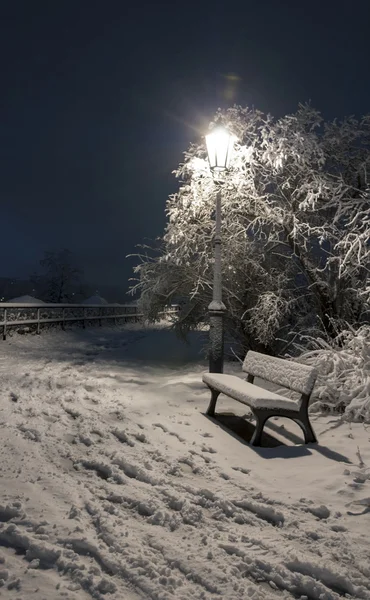 Bemch e lâmpada à noite com neve — Fotografia de Stock