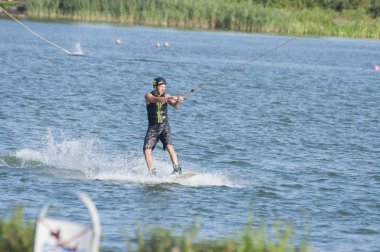 Wakeboard göl kenarında üzerinde Wakeboarder rides