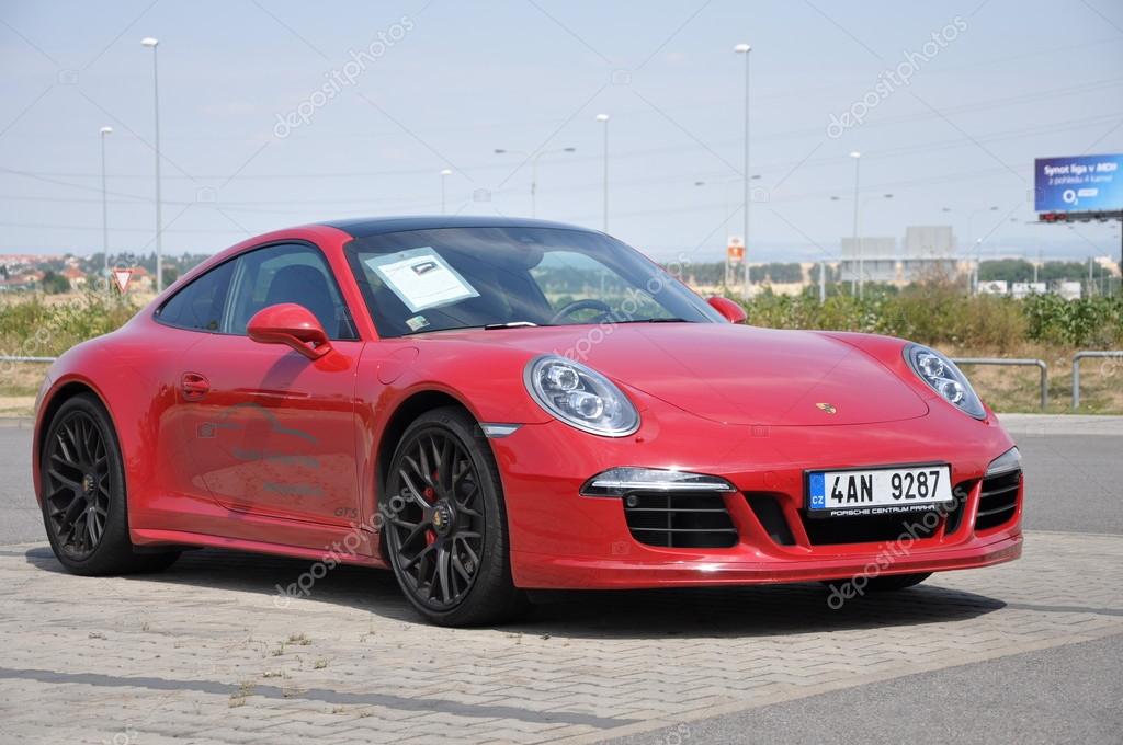 PRAGUE, THE CZECH REPUBLIC, 02.08.2015 - Luxury red Porsche 911 Carrera 4 GTS parking in front of a car store