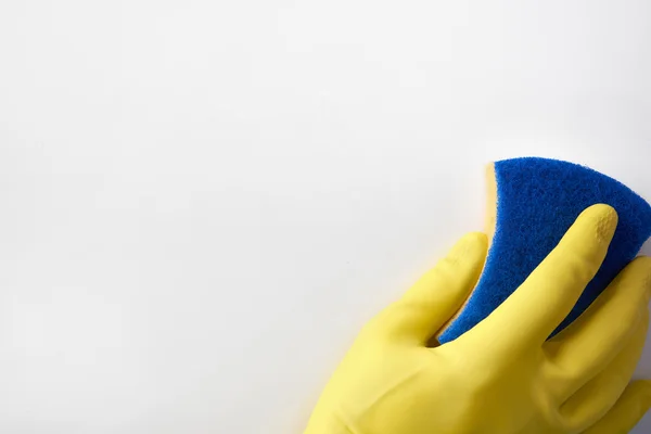 Hand met gele handschoen met vlies achtergrond — Stockfoto