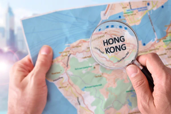 Man consulting a map of Hong Kong with magnifying glass