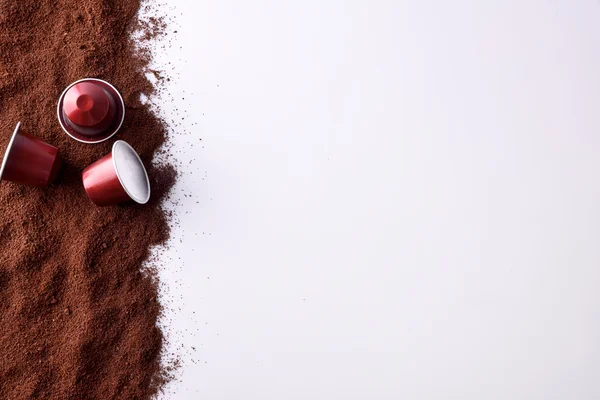 Tres cápsulas de café expreso en vista superior del café molido — Foto de Stock