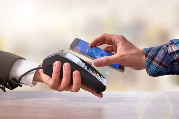 Customer paying a merchant with mobile phone nfc technology — Stock Photo, Image