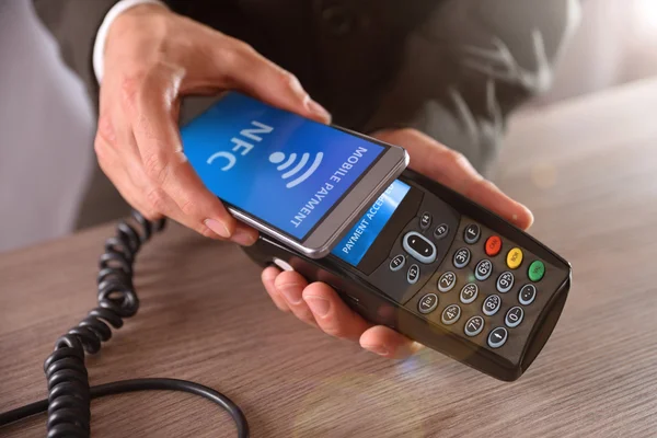 Empresário pagando através de tecnologia NFC móvel — Fotografia de Stock