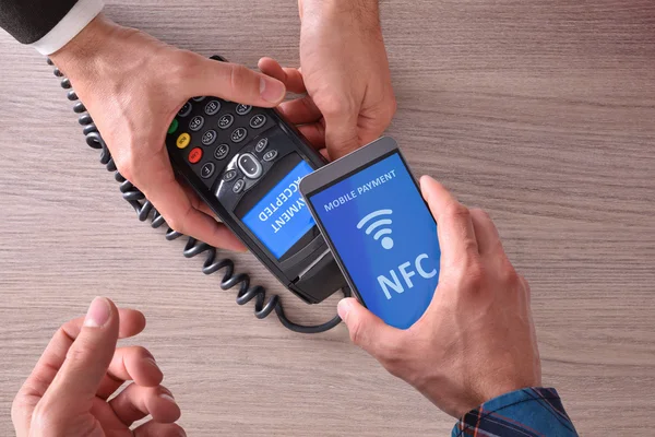 Customer paying a merchant with nfc top view — Stock Photo, Image