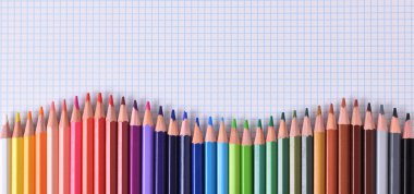 Dalga damalı sayfa paletinde renkli kalemler hizalı