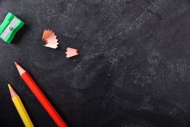 Bir kara tahta üzerinde sol tarafında okul malzemeleri 