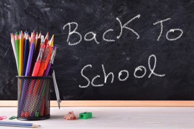 Konteyner ve pecils ile yazı tahtası üzerinde yazılı okula dönüş