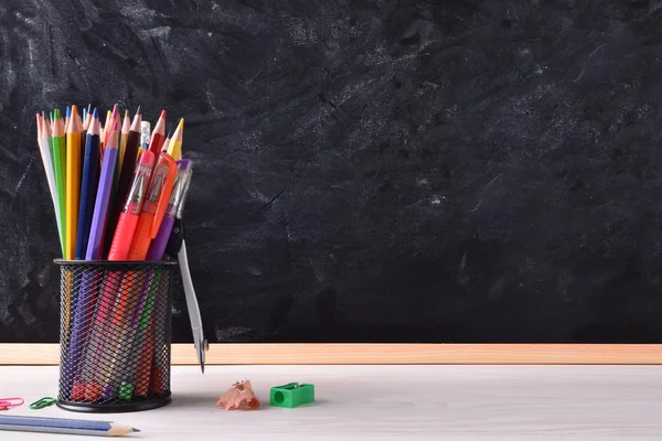 Skrivbord med skolan verktyg och blackboard plats rätt för titel — Stockfoto