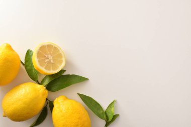 Yapraklı ve limonlu bir grup limon beyaz masada. Üst görünüm. Yatay bileşim.