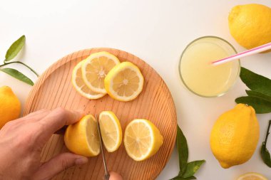 Mutfak tezgahında limonata hazırlamak için limon kesen eller. Üst Manzara. Yatay bileşim.