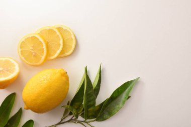 Beyaz bir masada kesilmiş ve dilimlenmiş organik limonla arka plan. Üst Manzara. Yatay bileşim.