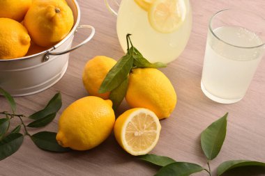 Taze hazırlanmış limon, su içeceği ve ahşap mutfak tezgahında çatal bıçak. Üst düzey görüş. Yatay bileşim.
