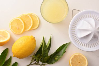 Tahtada limon dilimleri ve beyaz masadaki cam vazoda sıkılmış limon. Manzara yükseldi. Yatay bileşim.