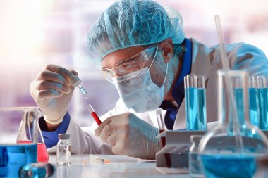 Laboratuvar araştırmacısı bir pipetle bir deney tüpüne numune koyuyor. Yatay bileşim. Ön görünüm.