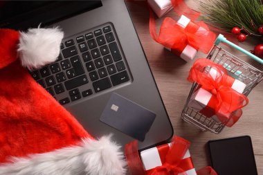 Bilgisayarlı, kartlı, alışveriş arabalı ve hediyeli kavramsal internet noel alışverişi. Üst Manzara. Yatay bileşim.