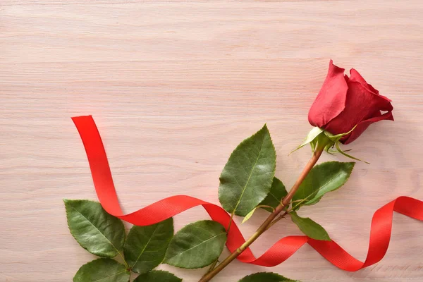 Ρομαντικό Φόντο Κόκκινο Τριαντάφυλλο Και Κόκκινη Κορδέλα Ξύλινο Τραπέζι Άνω — Φωτογραφία Αρχείου