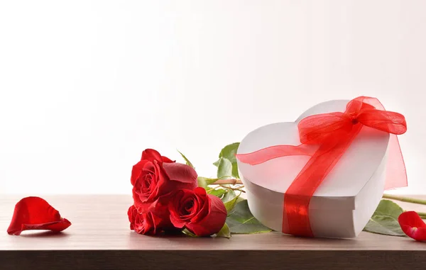 Μπουκέτο Τριαντάφυλλα Και Λευκό Κουτί Δώρου Κόκκινο Τόξο Ξύλινο Τραπέζι — Φωτογραφία Αρχείου