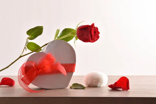 Τριαντάφυλλο Στηρίζεται Κουτί Δώρου Σχήμα Καρδιάς Και Πέταλα Ξύλινο Τραπέζι — Φωτογραφία Αρχείου