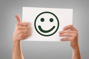 İki el beyaz çarşafı yatay olarak tutuyor. Mutlu yüz ifadeleri var. Parmakları var.