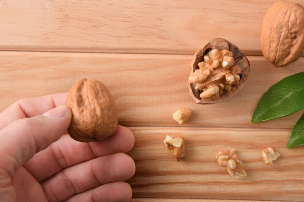 Detail Hand Showing Walnuts Wooden Table Broken Shell Chunks Top — Stock Photo, Image